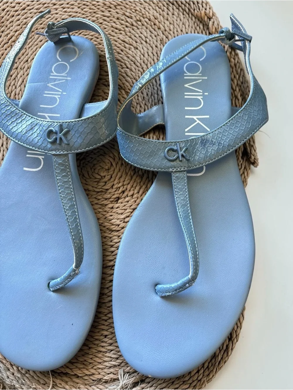 Calvin Klein Shellie blue snake print flat thong sandals feature an ankle strap